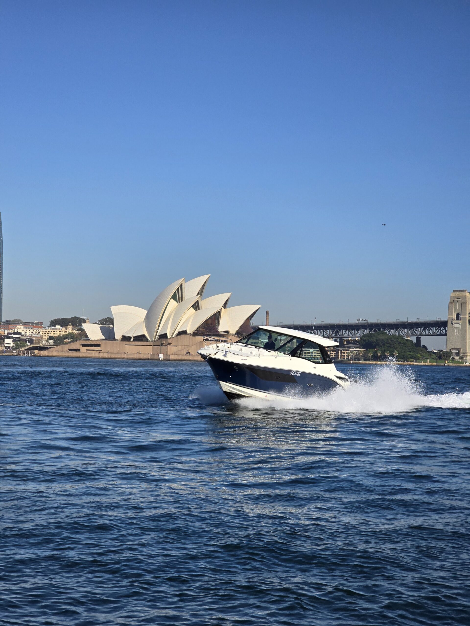 A large, white luxury motor yacht with a sleek design is docked at a marina.